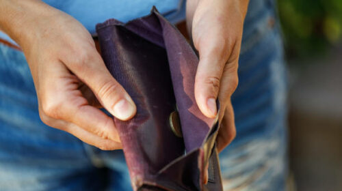Open purse with coins inside close-up as a sign of lack of money